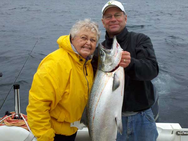 June & Don with King  - Leprechaun Fishing Charters on Lake Michigan